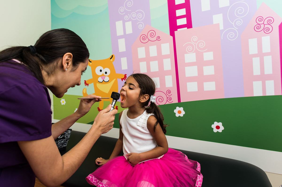 Pediatrician examining a young girl during a checkup at ABC Pediatric Clinic